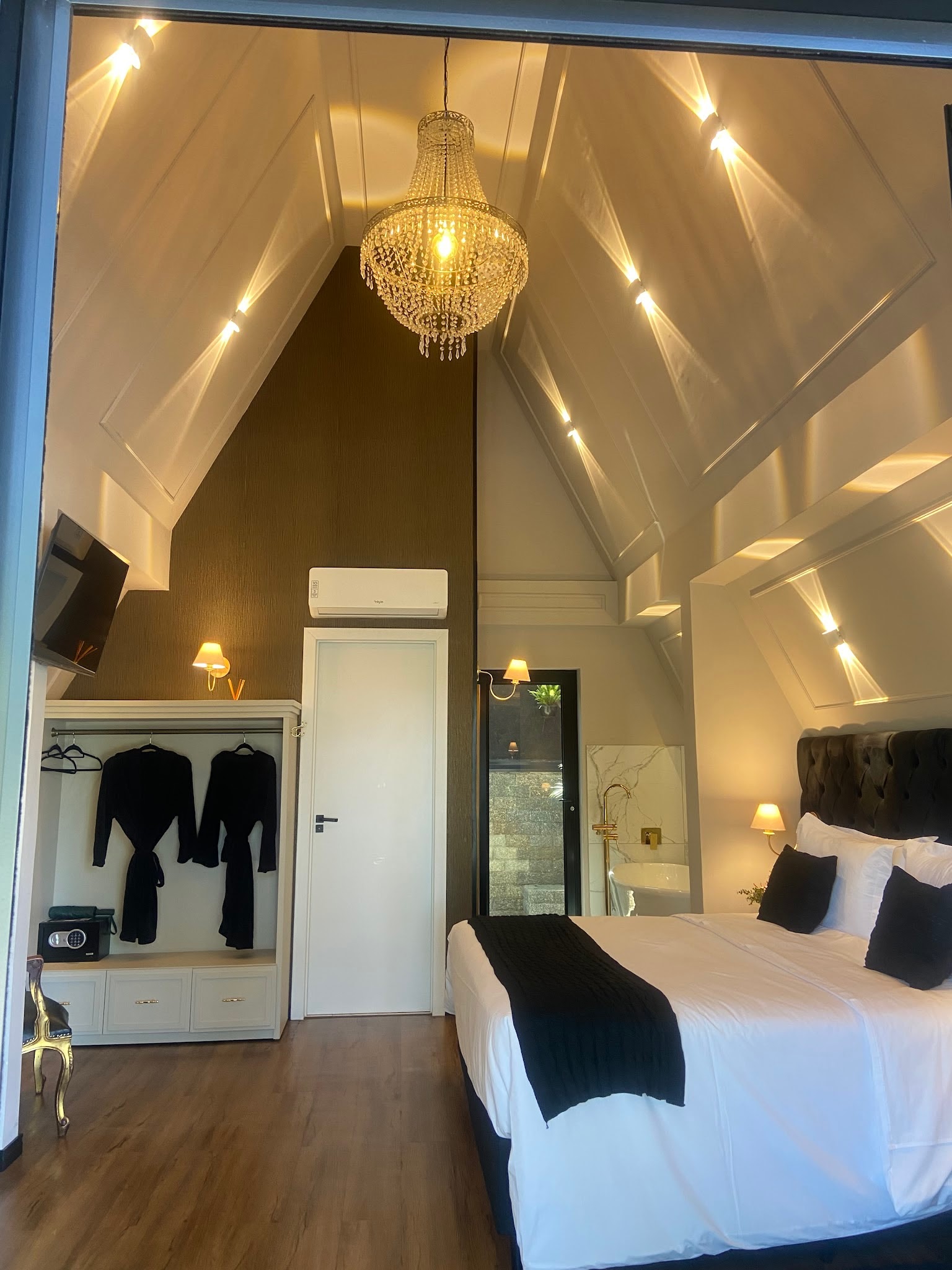 Chalé com cama king e roupões pendurados no closet aberto