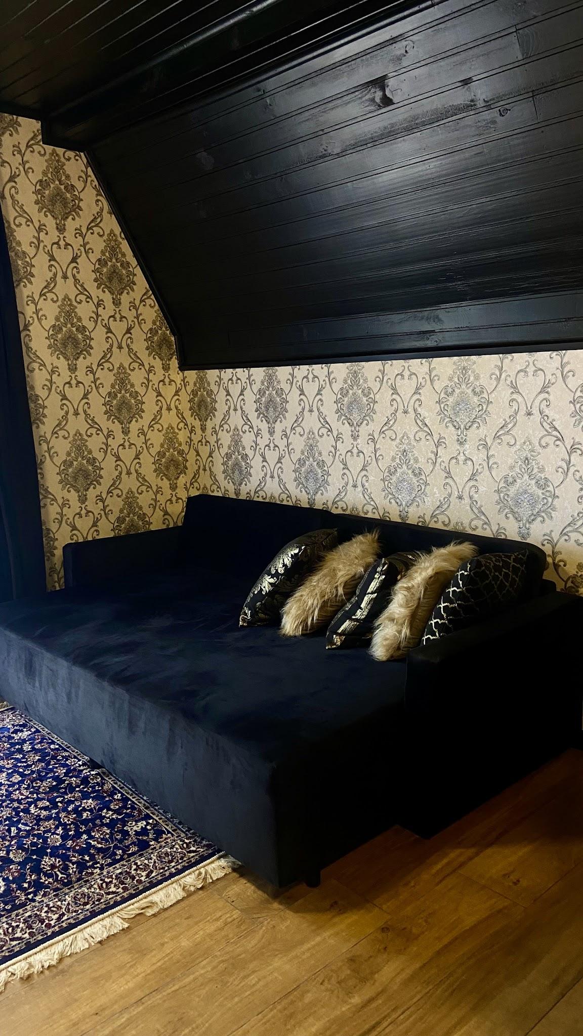 Sofá de veludo azul do Chalé Duplex sob a inclinação do telhado
