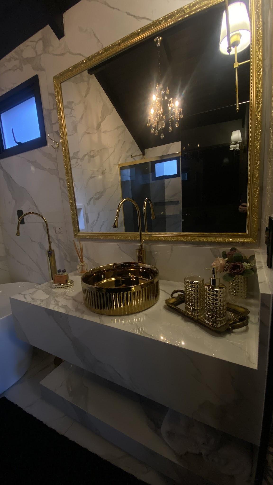 Bancada de mármore do Chalé Duplex com espelho de moldura dourada e amenities