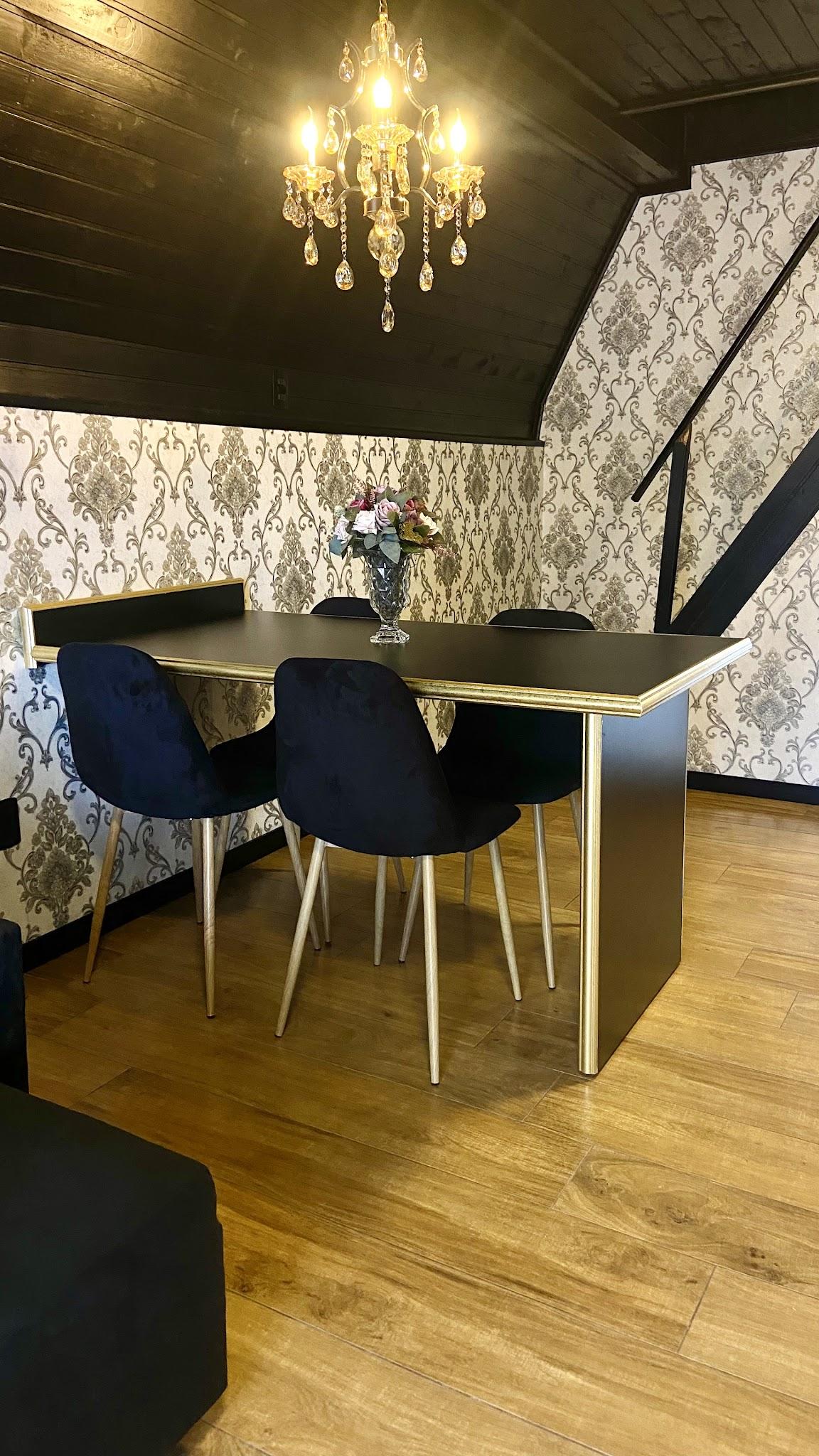 Mesa de jantar do Chalé Duplex com cadeiras azuis e papel de parede damasco
