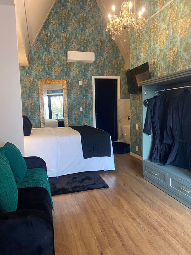 Suíte com decoração verde e roupões no Villa Verde