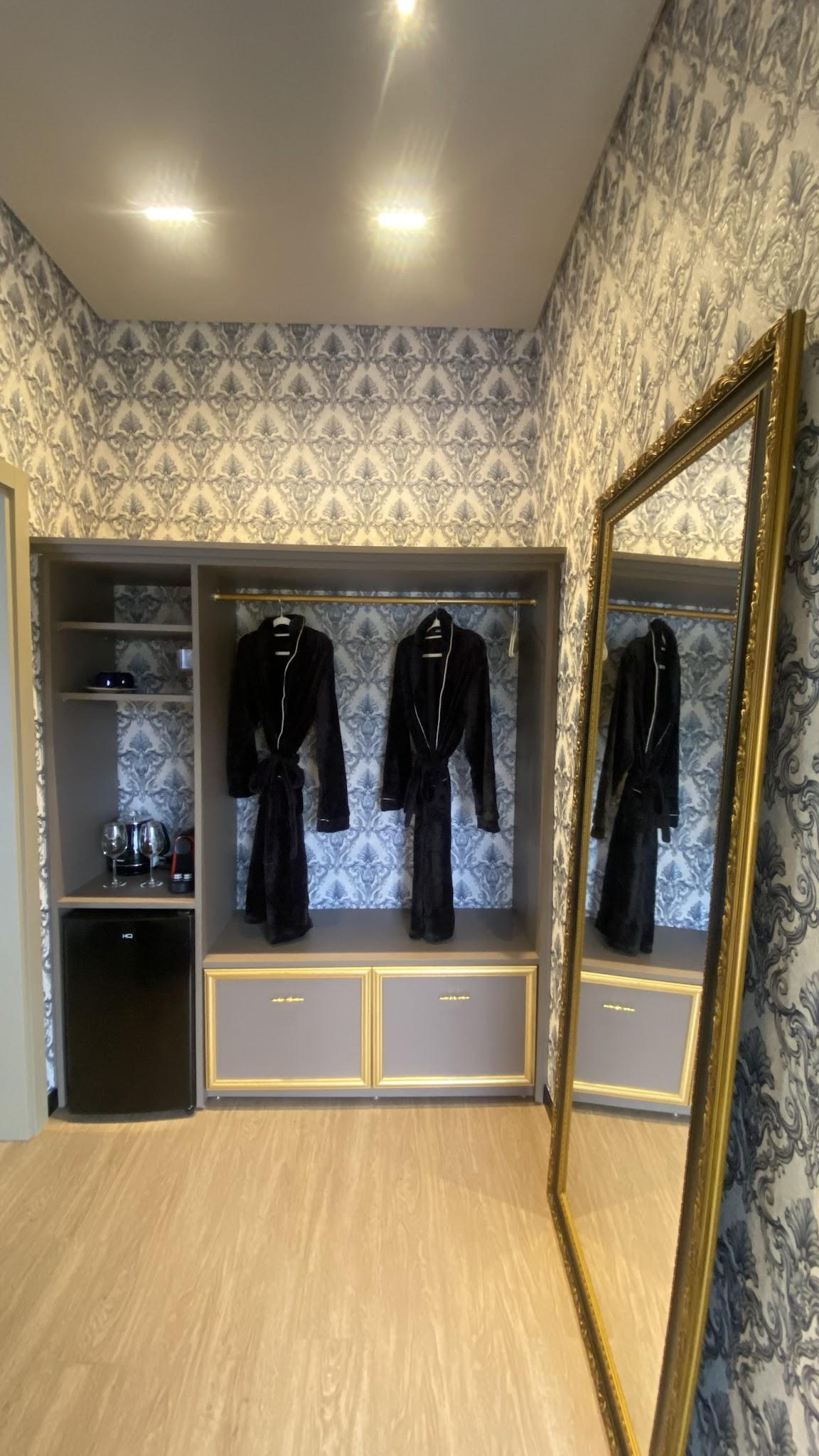 Closet da Suíte Royale com portas de vidro, roupões e espelho de corpo inteiro
