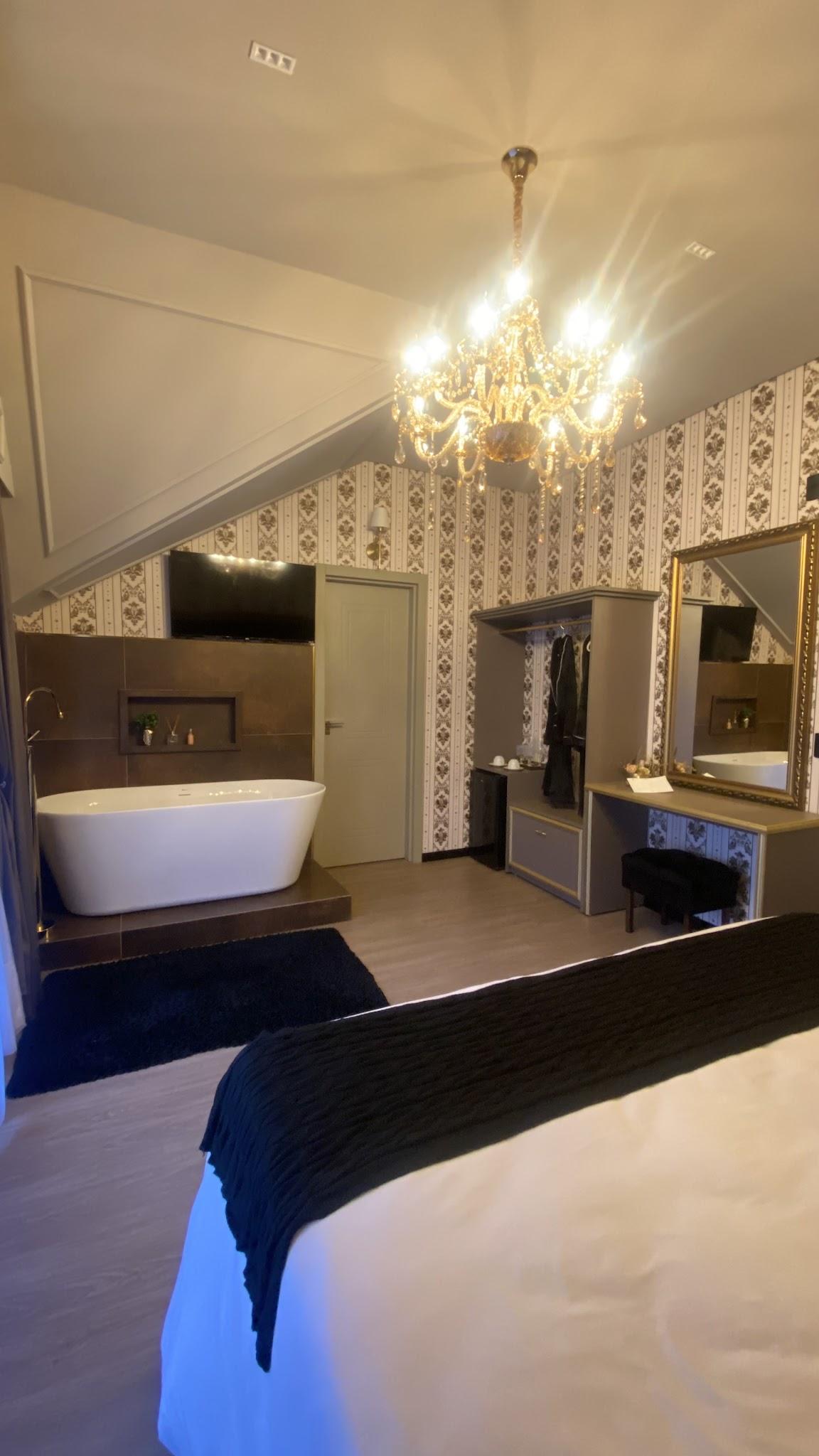 Suíte Versailles vista da cama, com banheira de imersão e penteadeira ao fundo