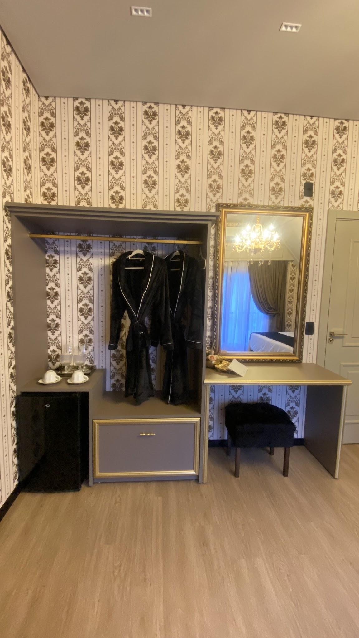 Closet e penteadeira da Suíte Versailles com espelho de corpo inteiro e roupões